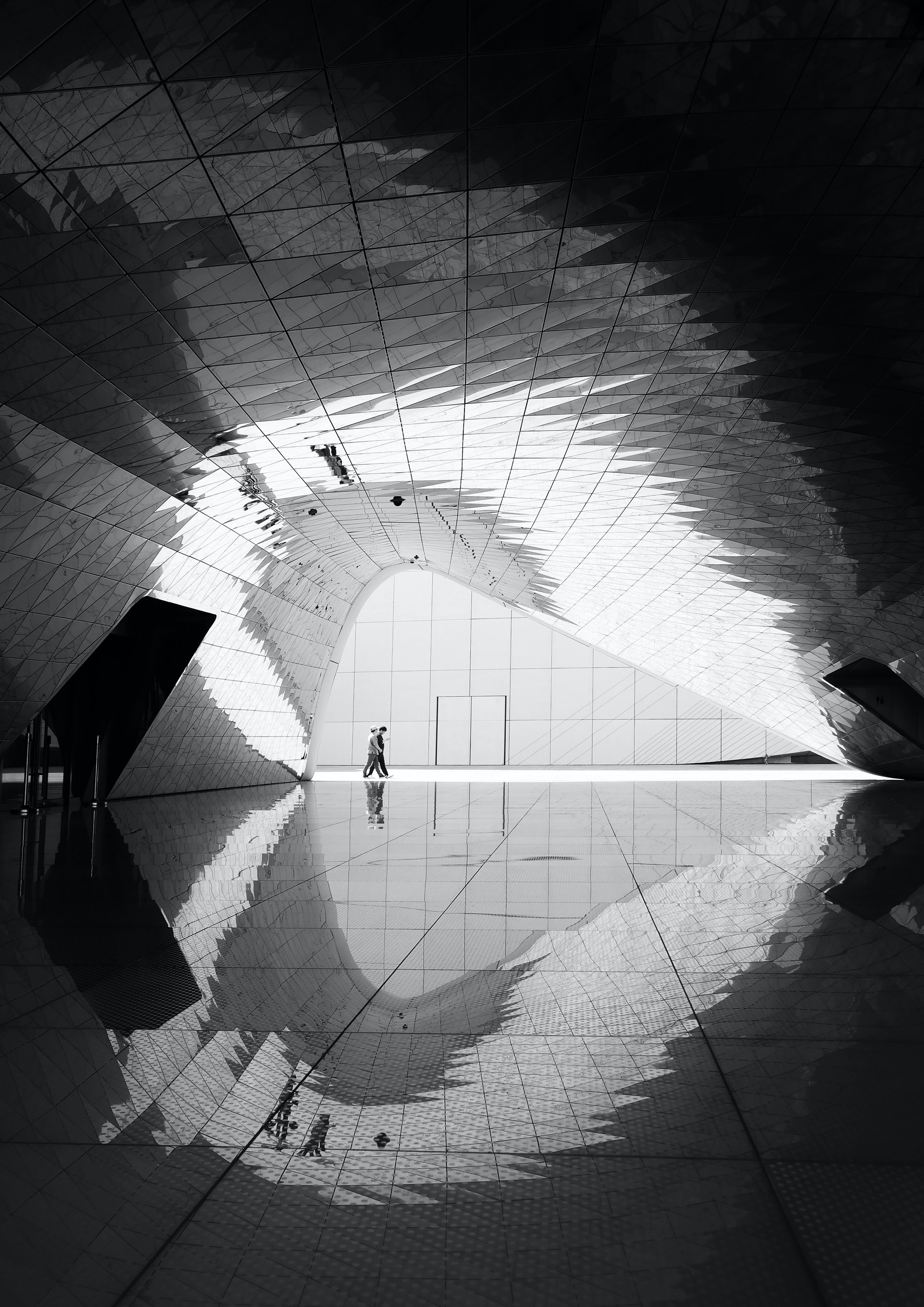 Bilde tatt i en moderne tunell i et bygg, to mennesker som går er fotografert
